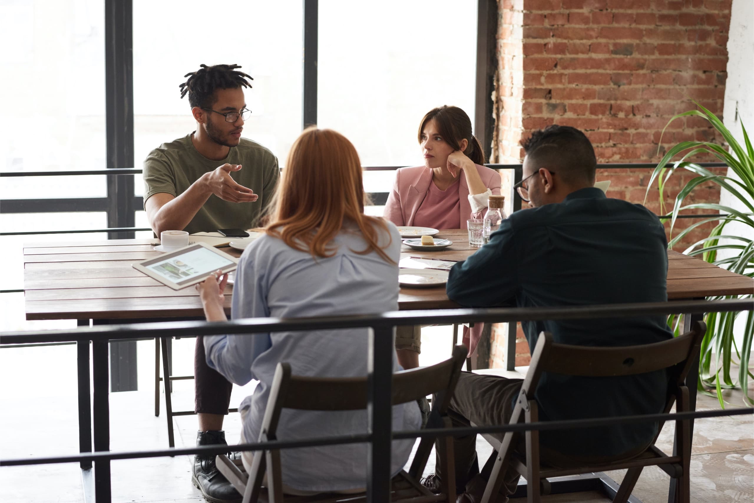 Group of four sitting at a table, discussing an issue