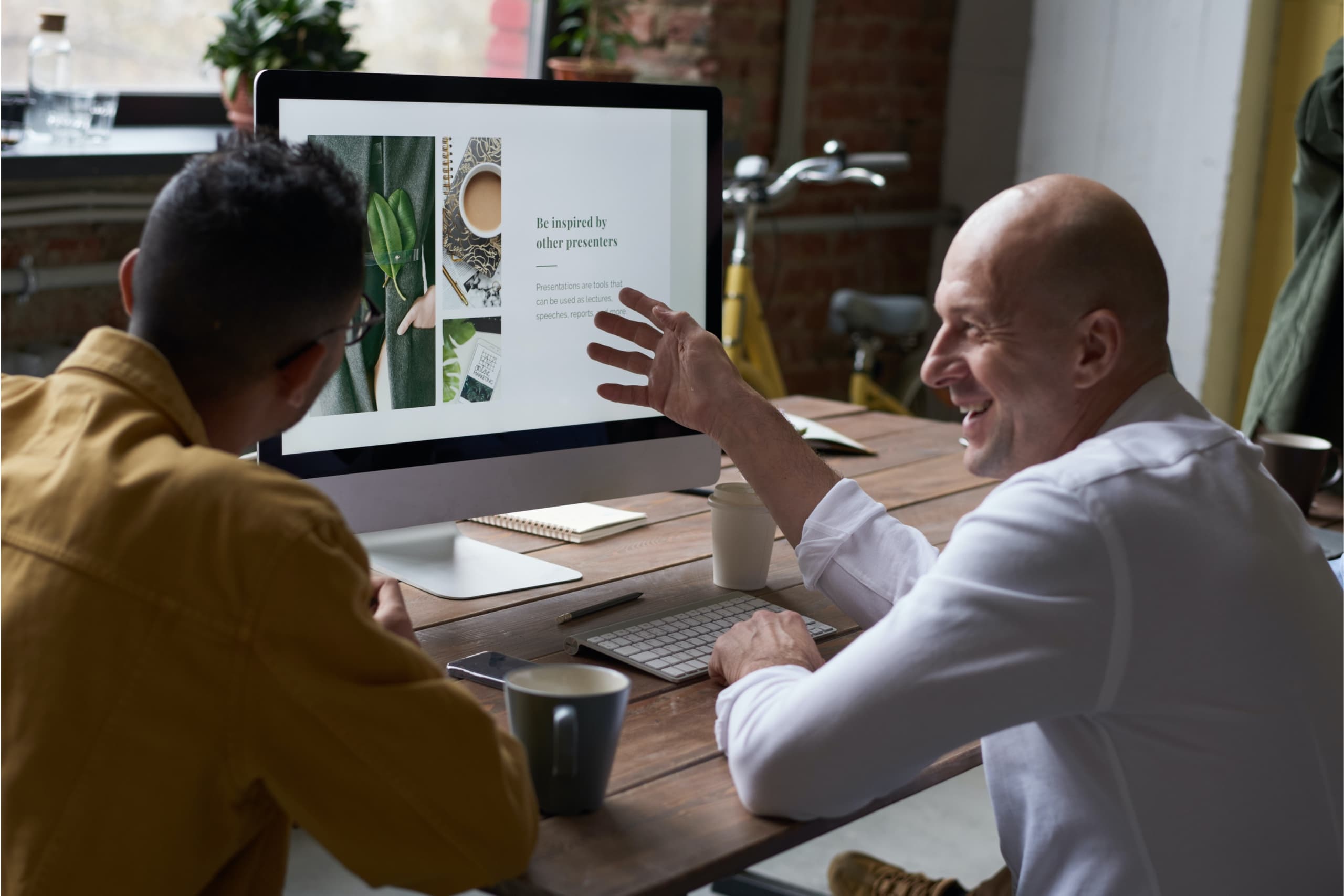 Two people looking at a computer screen and discussing the content in a friendly manner