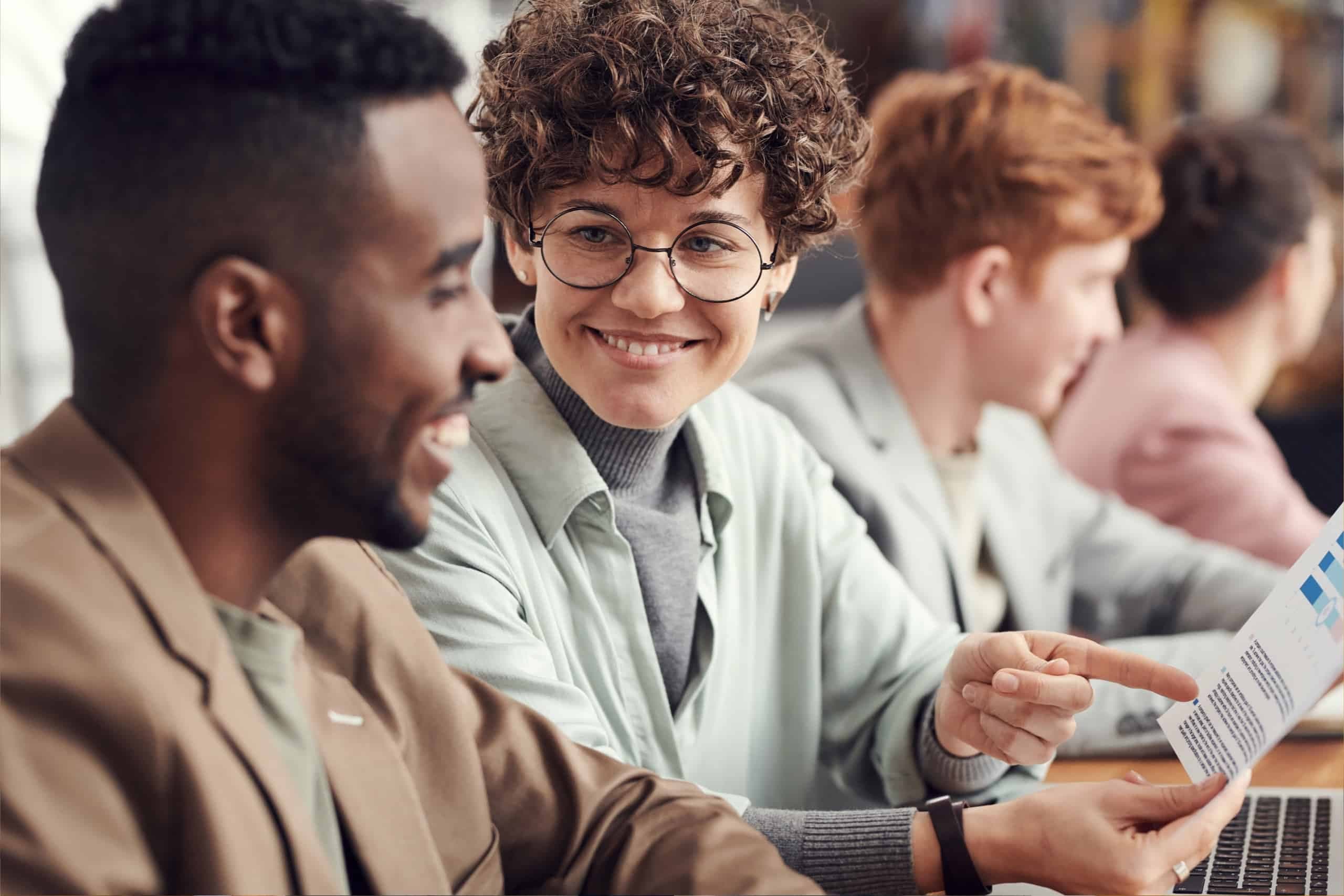 Two people sitting together, one person happily points at document