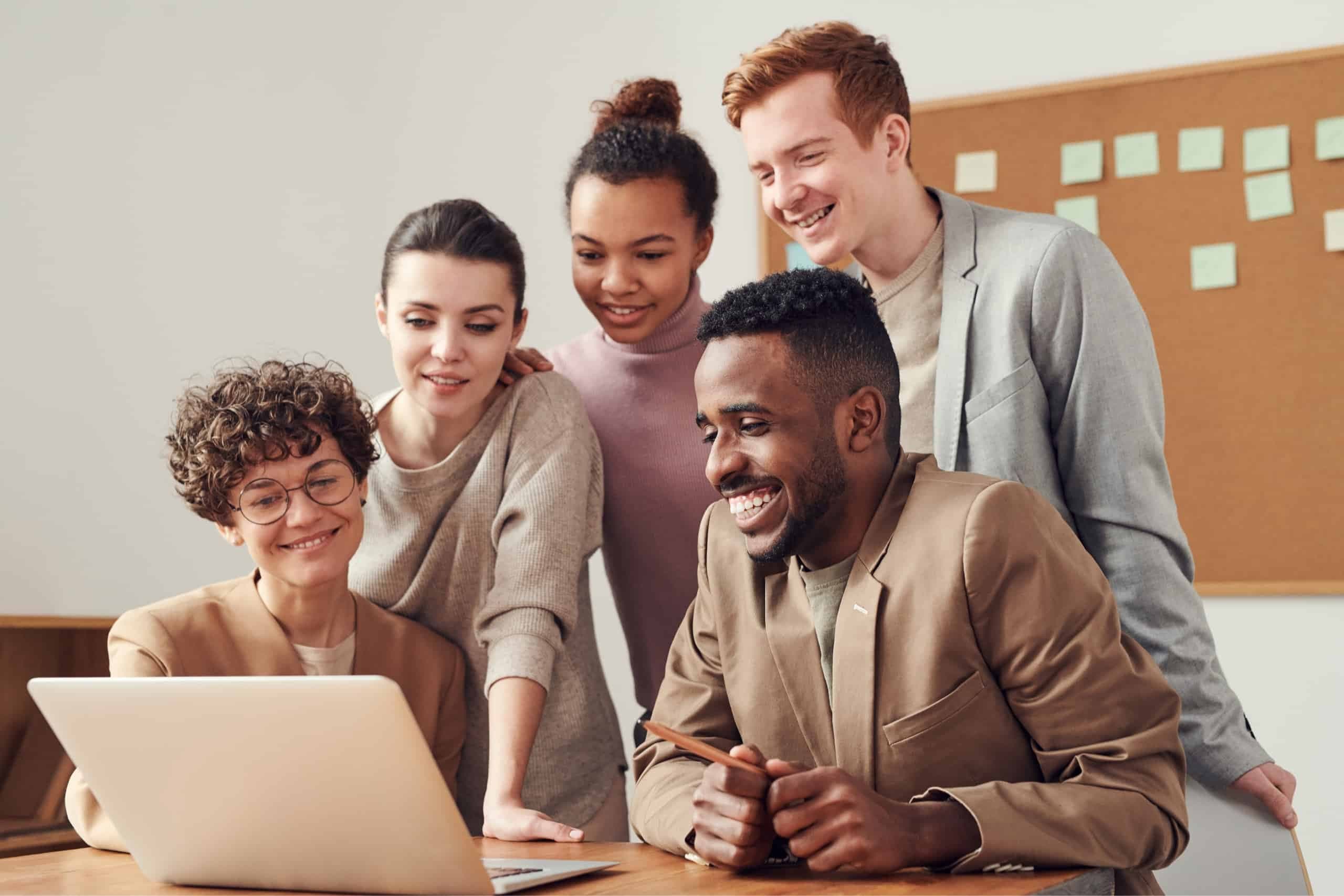 Happy team looking at a laptop screen