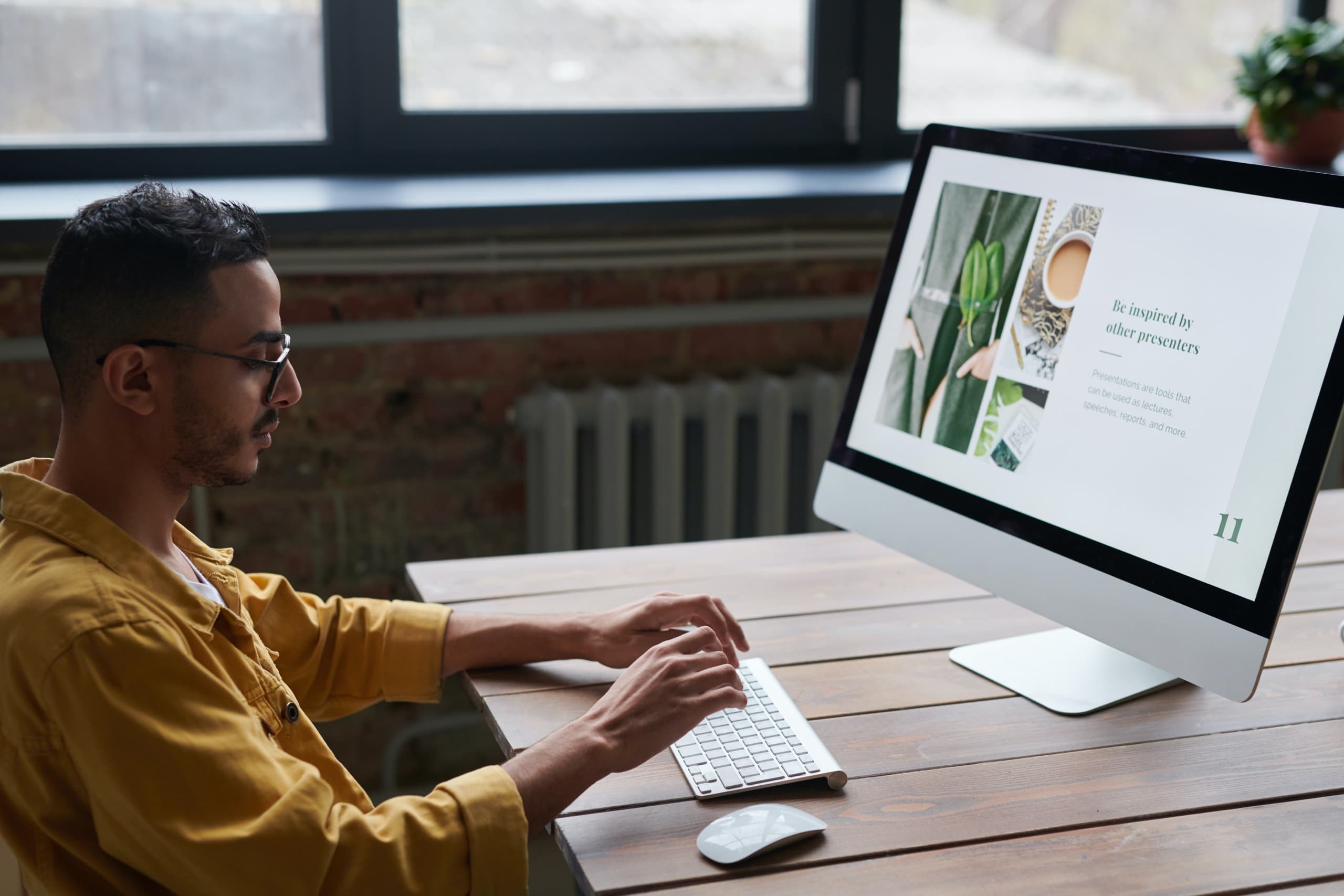 Man sitting behind a computer, working on a presentation