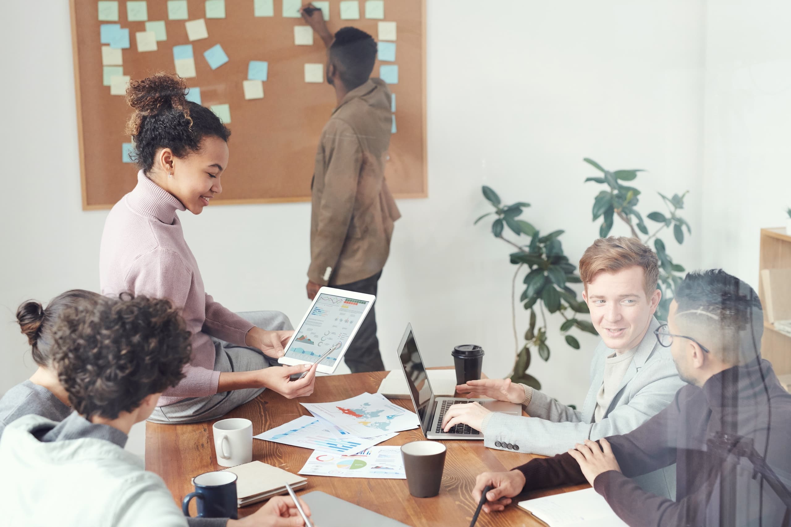 Team working together around a table and sticky note board