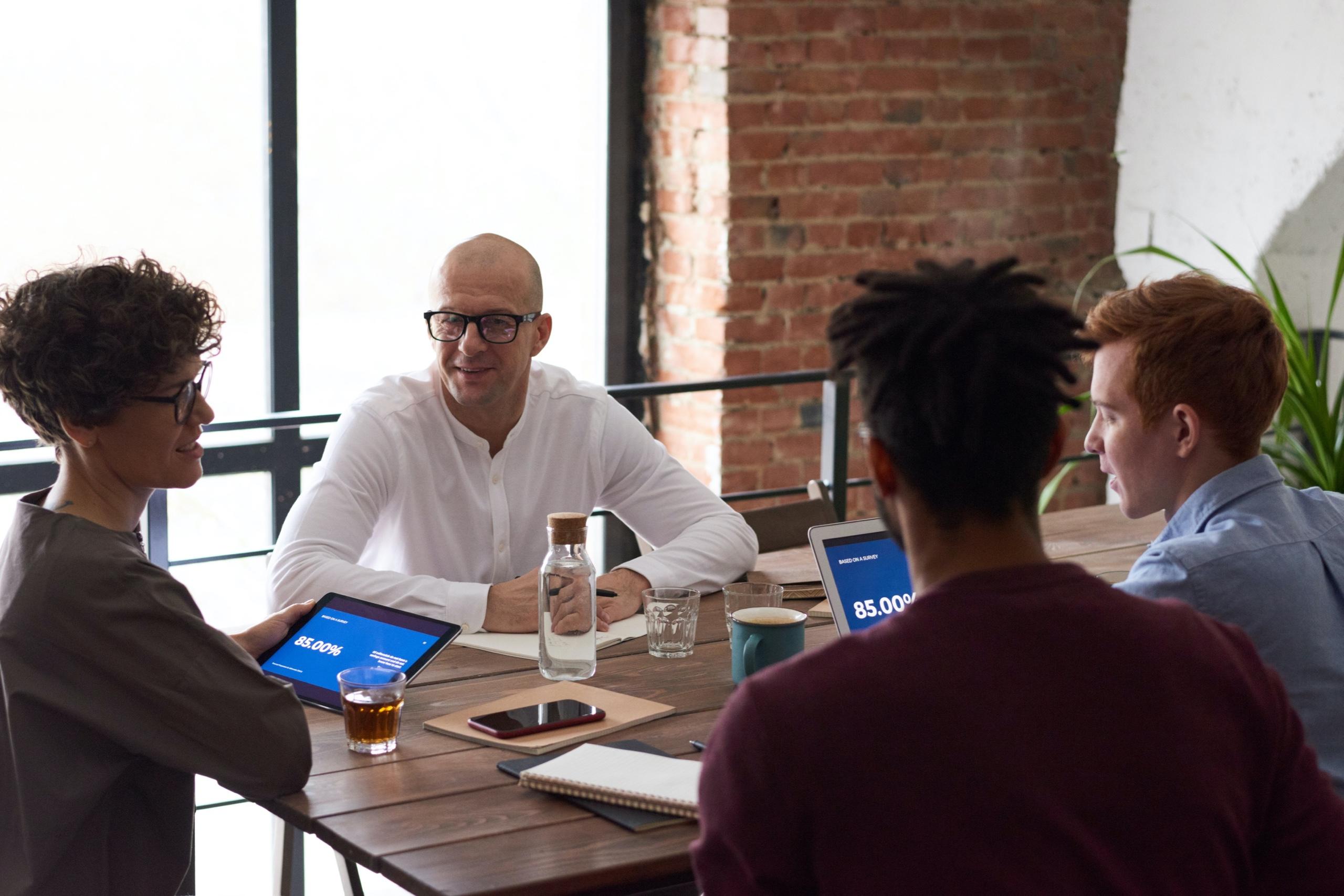 Team of four colleagues discussing around a table